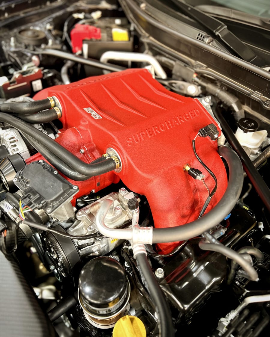 Supercharged engine bay with a red intake manifold