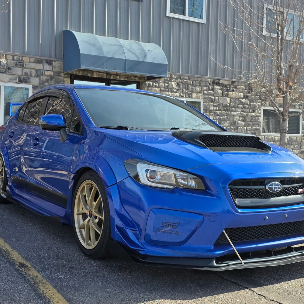 Blue Subaru WRX STI outside the shop
