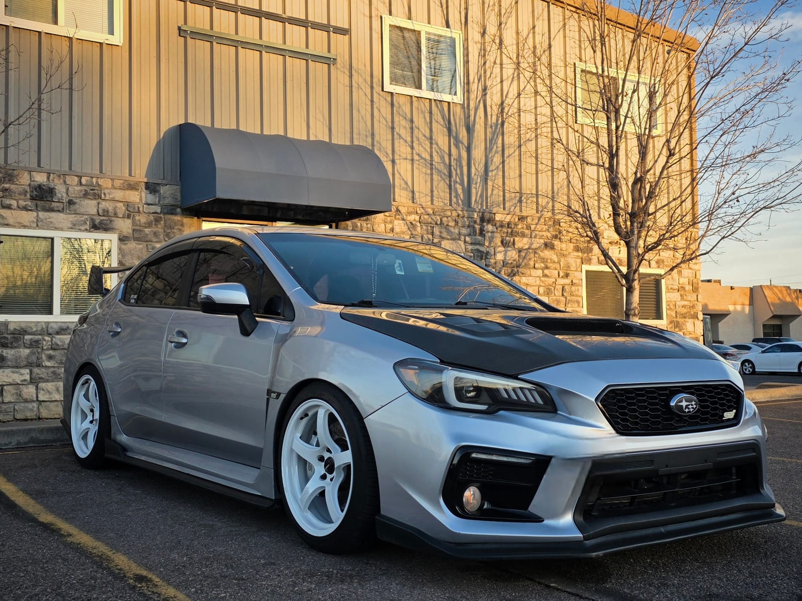 Silver Subaru WRX STI outside the shop at sunset
